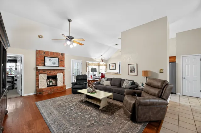 a living room with furniture a fireplace and a flat screen tv