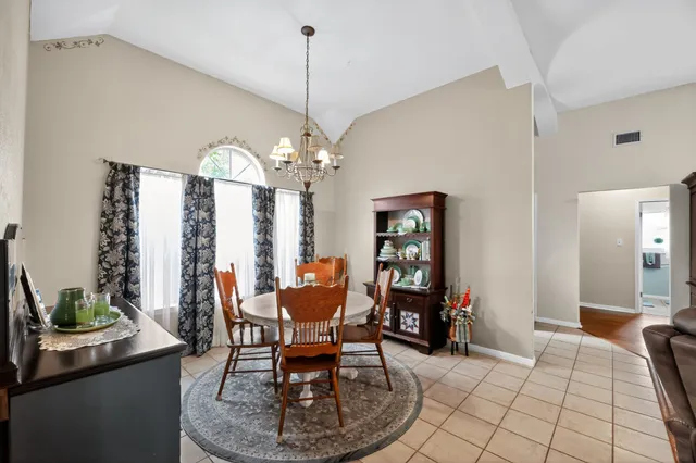 a dining room with furniture a chandelier and window