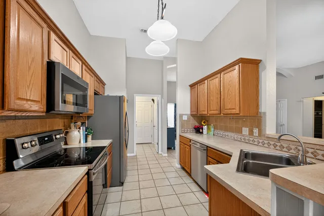 a kitchen with stainless steel appliances granite countertop a sink stove and refrigerator