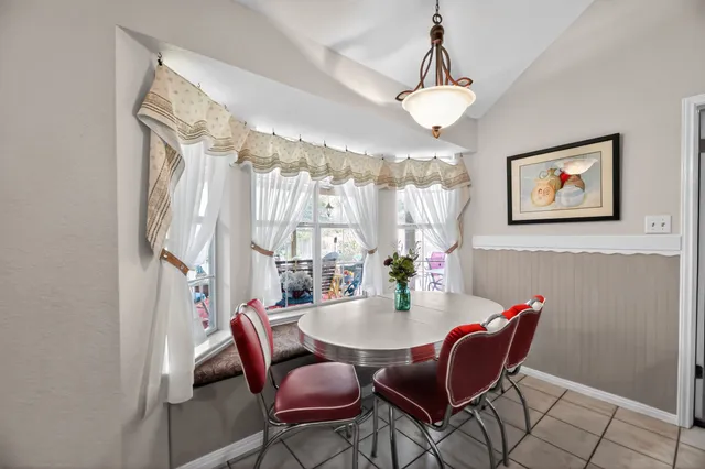 a dining room with furniture a chandelier and window