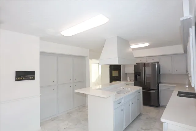 a kitchen with a refrigerator sink and cabinets