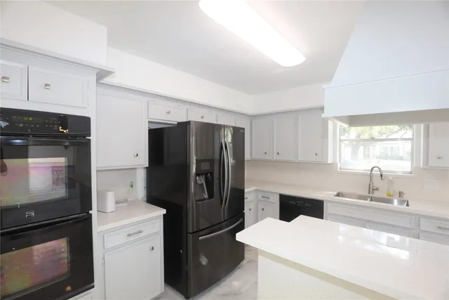 a view of an empty room with a chandelier fan