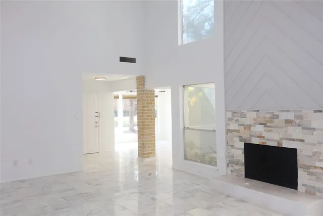 an empty room with fireplace and windows