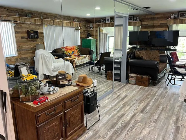 a living room with furniture a flat screen tv and a floor to ceiling window