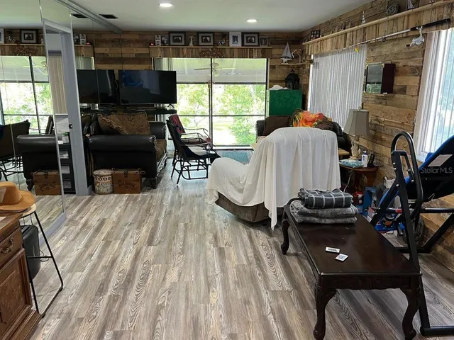 a living room with furniture a window and wooden floor