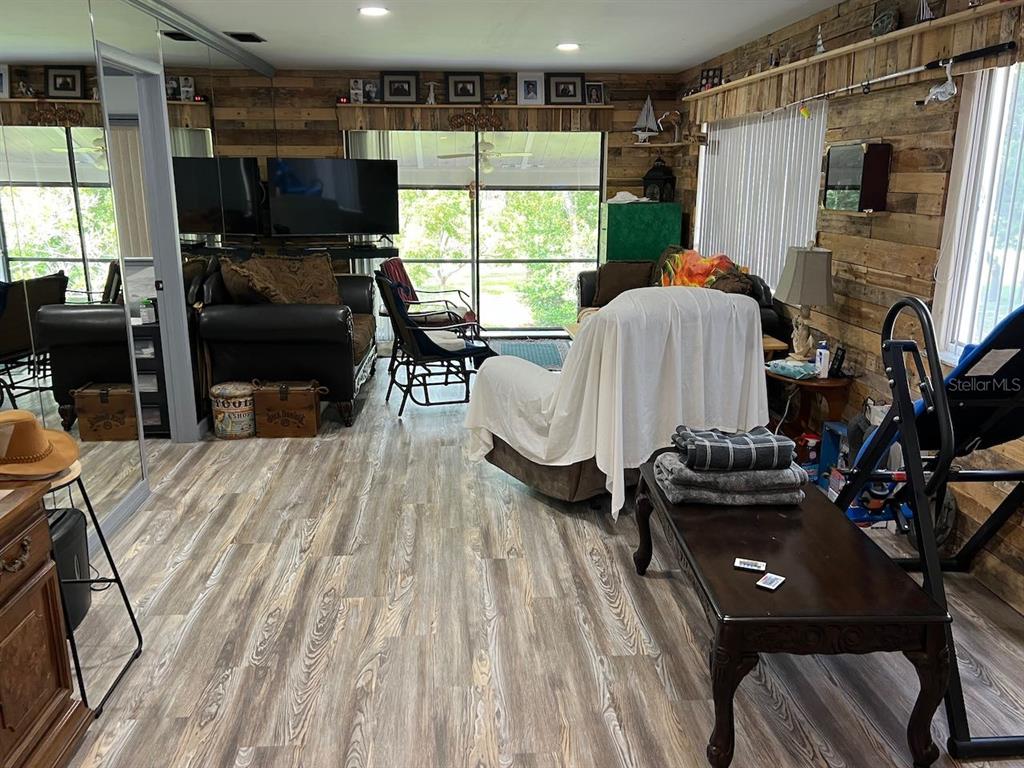 12908 Wedgewood Way, Unit D Hudson, FL 34667 - Photo 18 of 55 a living room with furniture a flat screen tv and a floor to ceiling window