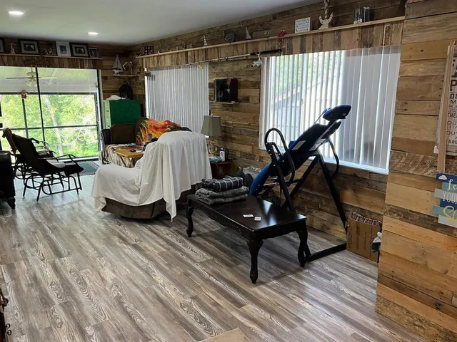 a bed sitting in a bedroom next to a window with wooden floor