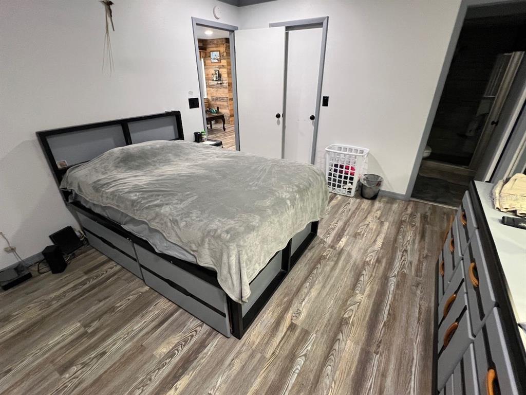 12908 Wedgewood Way, Unit D Hudson, FL 34667 - Photo 20 of 55 a bed sitting in a bedroom next to a window with wooden floor