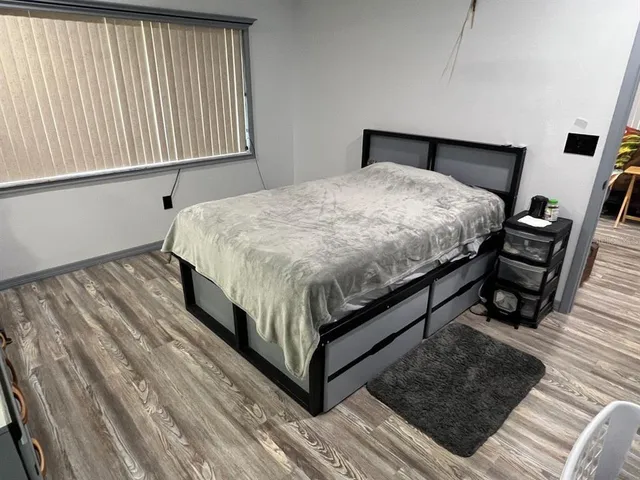 a bedroom with a bed and a flat tv screen on dresser