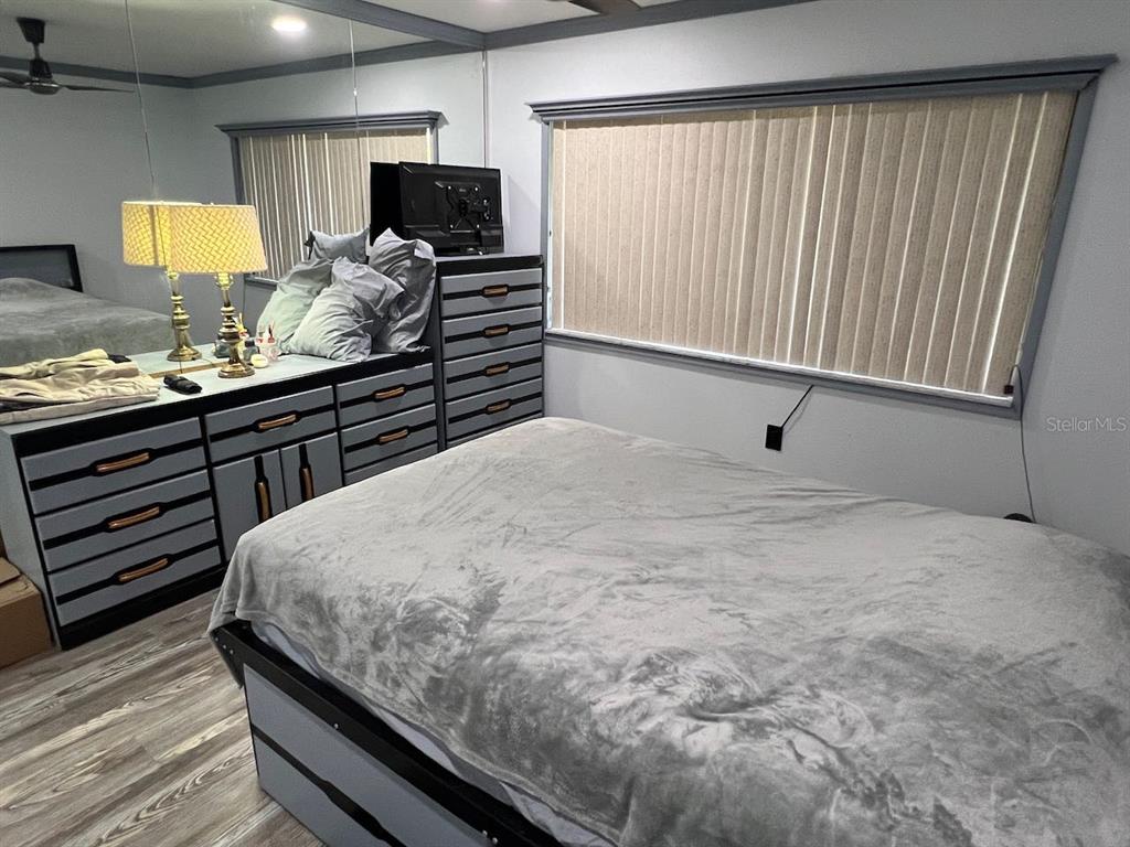 12908 Wedgewood Way, Unit D Hudson, FL 34667 - Photo 24 of 55 a bedroom with a bed and a flat tv screen on dresser