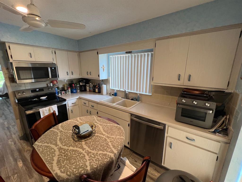 12908 Wedgewood Way, Unit D Hudson, FL 34667 - Photo 31 of 55 a kitchen with a stove a sink and a microwave