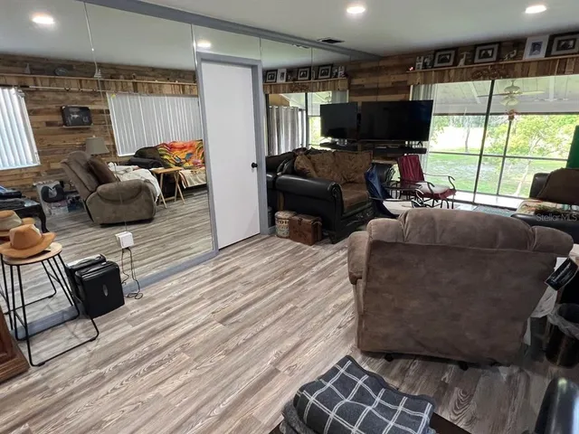a living room with furniture a flat screen tv and a mirror