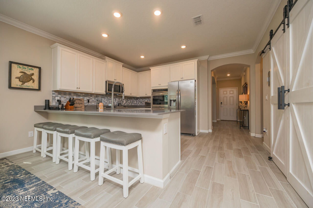 77 Glorieta Drive St. Augustine, FL 32095 - Photo 12 of 67 a kitchen with stainless steel appliances granite countertop a refrigerator and a stove top oven