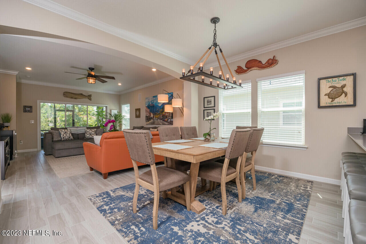 77 Glorieta Drive St. Augustine, FL 32095 - Photo 14 of 67 a dining room with wooden floor a chandelier a wooden table and chairs