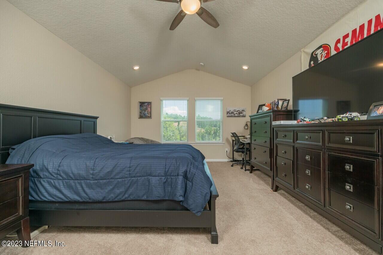 77 Glorieta Drive St. Augustine, FL 32095 - Photo 32 of 67 a bedroom with a bed and a chandelier