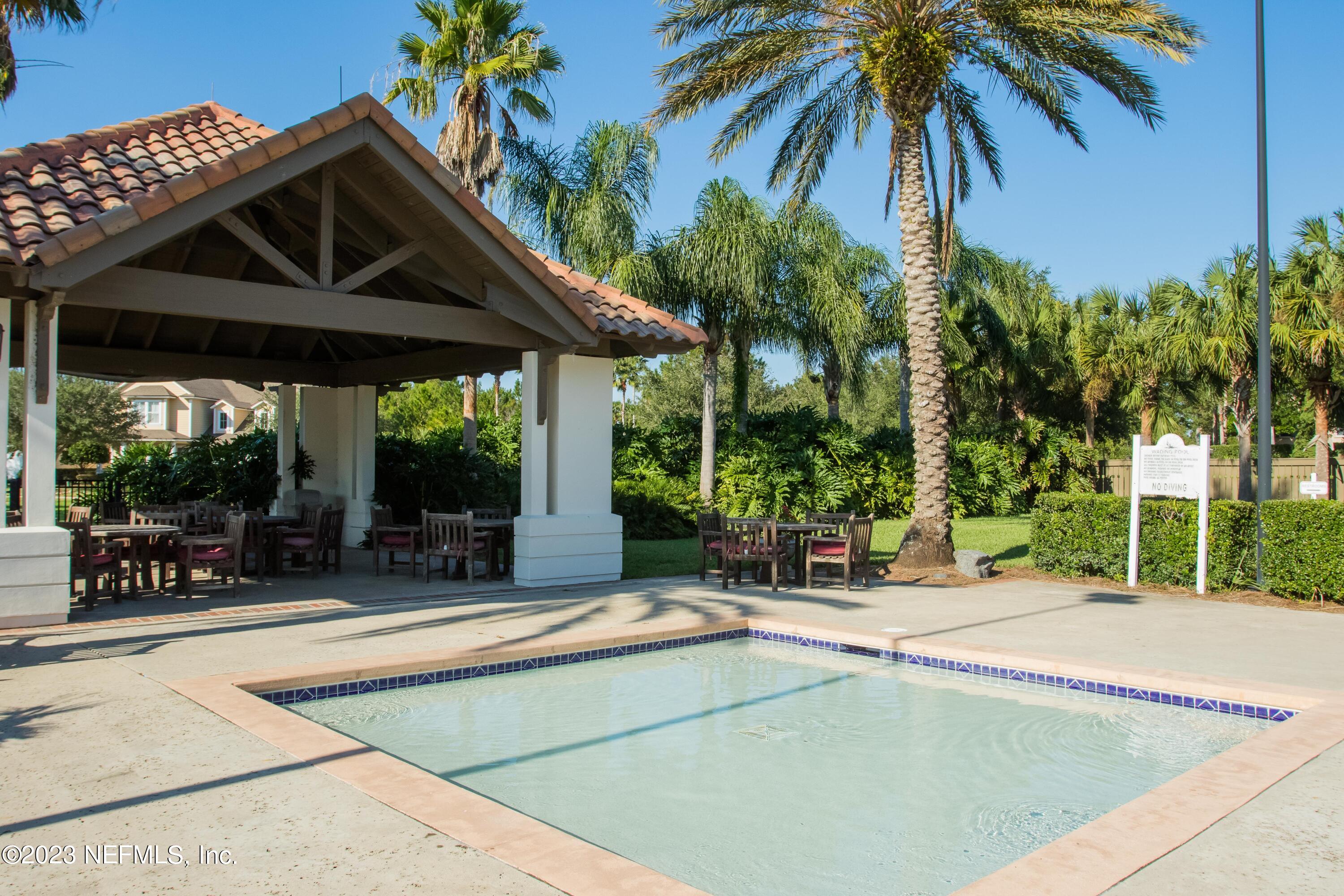 77 Glorieta Drive St. Augustine, FL 32095 - Photo 54 of 67 a view of a patio with a table and chairs under an umbrella