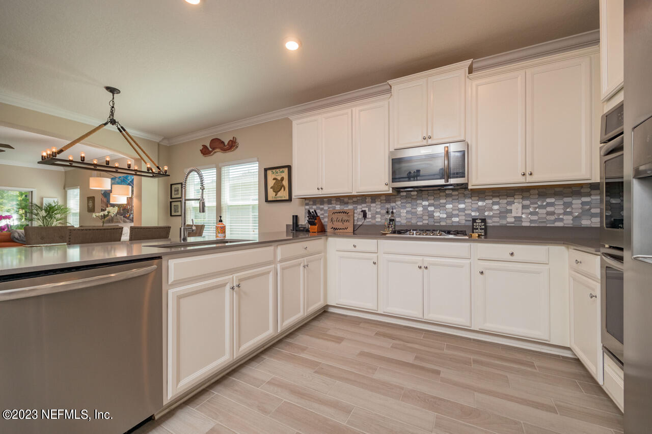 77 Glorieta Drive St. Augustine, FL 32095 - Photo 9 of 67 a kitchen with granite countertop white cabinets and white appliances