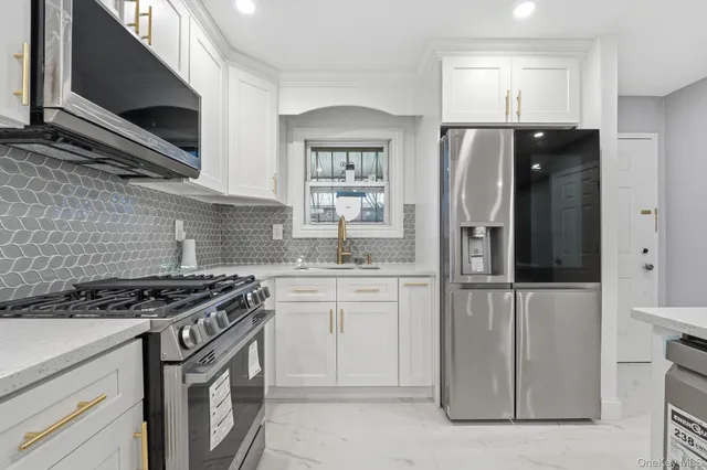 a kitchen with stainless steel appliances granite countertop a stove a refrigerator and a microwave