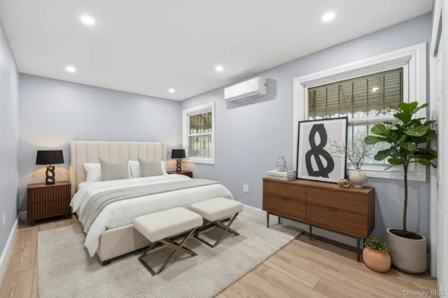 a spacious bedroom with a bed and a potted plant