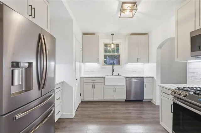 a kitchen with white cabinets and stainless steel appliances