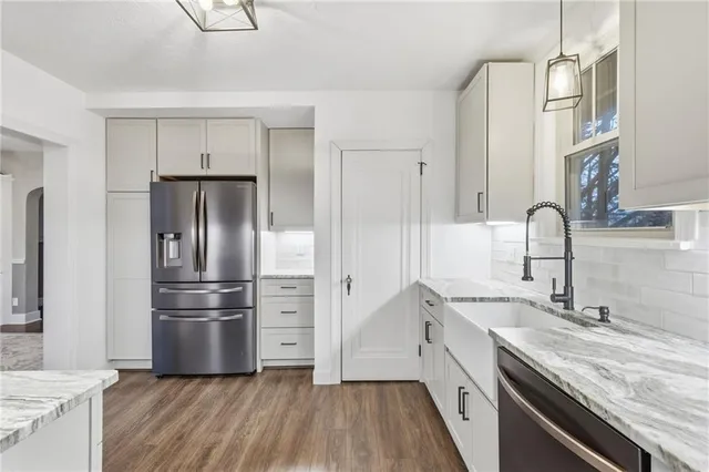 a kitchen with granite countertop a refrigerator and a sink