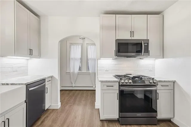 a kitchen with granite countertop a stove and a microwave