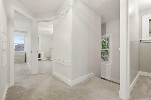 an empty room with windows and cabinet