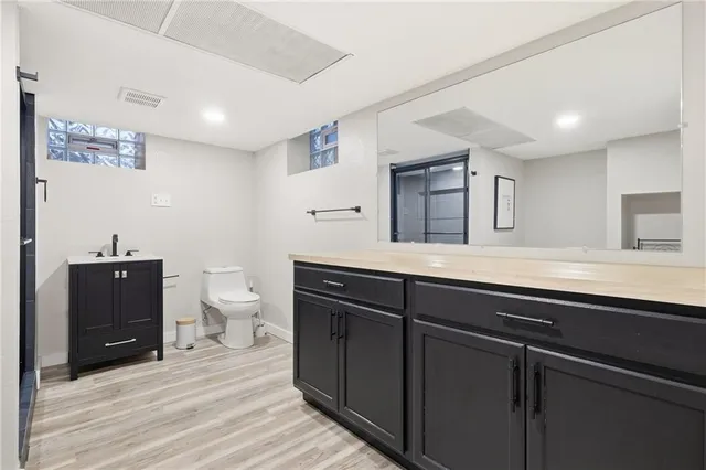 a bathroom with a toilet a sink and glass door