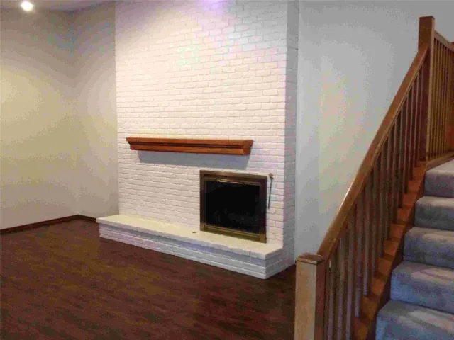 a view of a livingroom with wooden floor and staircase