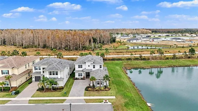 an aerial view of a house with swimming pool and yard