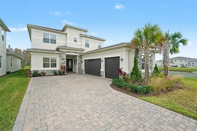 a front view of a house with a yard and potted plants