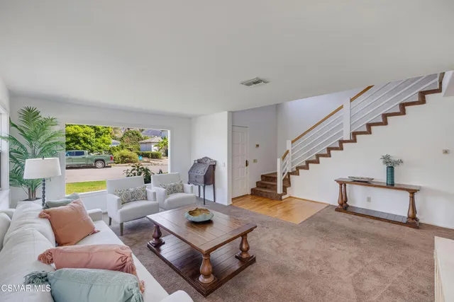 a living room with furniture and a floor to ceiling window