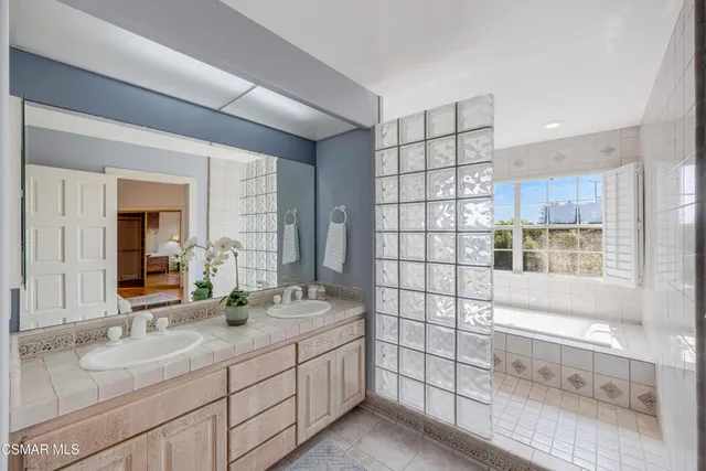 a bathroom with a tub sink and mirror
