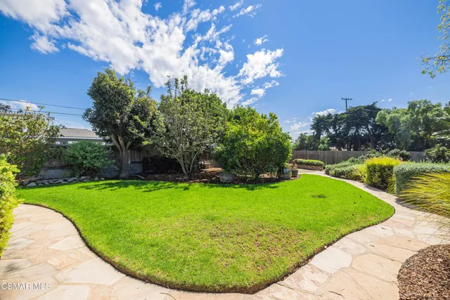 a view of a backyard with sitting area and garden