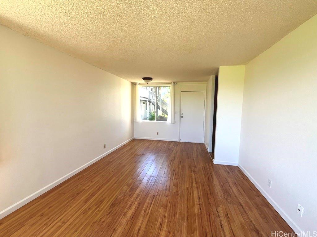 95-670 Hanile Street, Unit A102 Mililani, HI 96789 - Photo 4 of 13 an empty room with wooden floor and windows