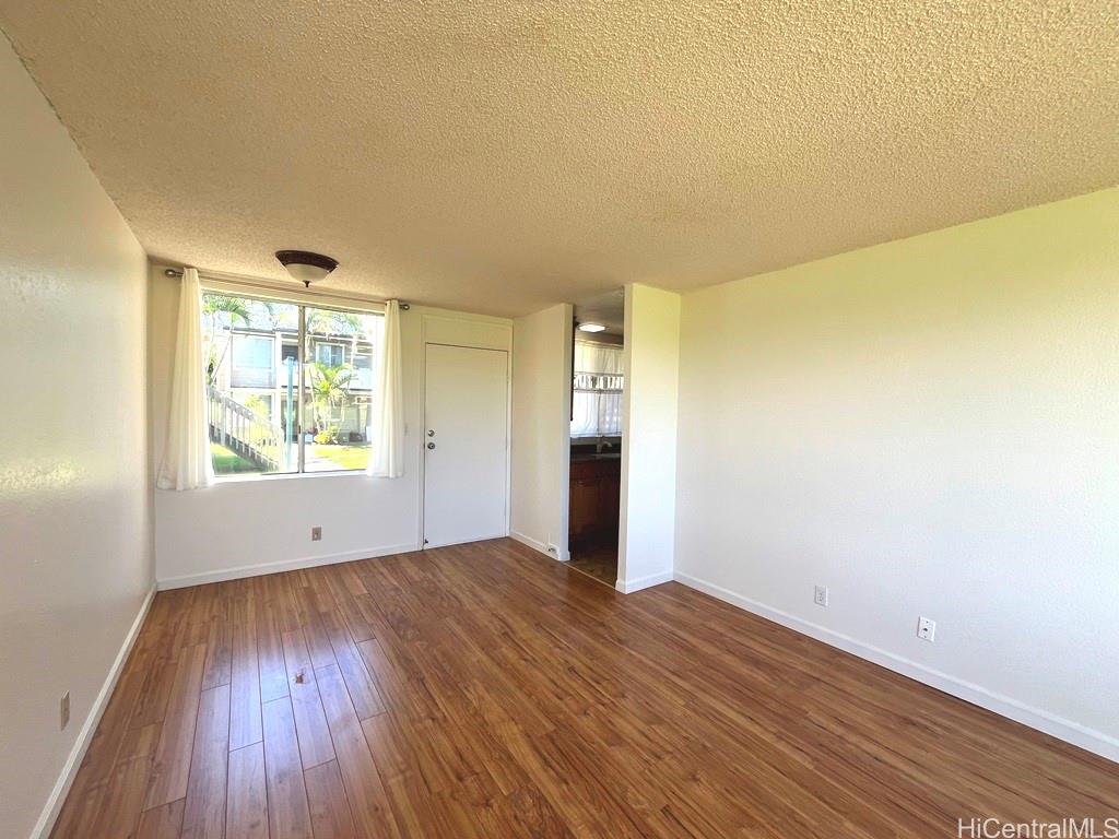 95-670 Hanile Street, Unit A102 Mililani, HI 96789 - Photo 5 of 13 a view of an empty room with wooden floor and a window