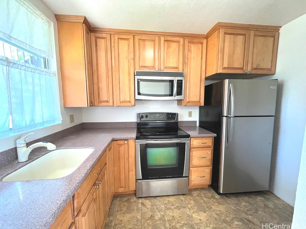 95-670 Hanile Street, Unit A102 Mililani, HI 96789 - Photo 6 of 13 a kitchen with a refrigerator and a sink