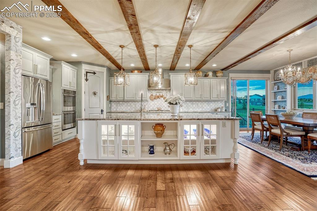 1935 Bashley Road Monument, CO 80132 - Photo 2 of 45 a kitchen with stainless steel appliances granite countertop a refrigerator a sink dishwasher a stove and white countertops with wooden floor