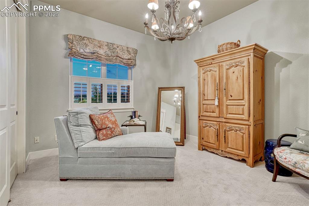 1935 Bashley Road Monument, CO 80132 - Photo 25 of 45 a spacious bedroom with furniture and a chandelier