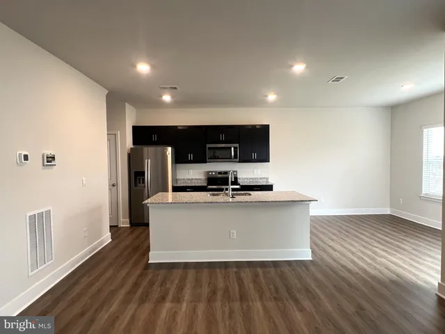 a view of kitchen with microwave stove refrigerator and cabinets
