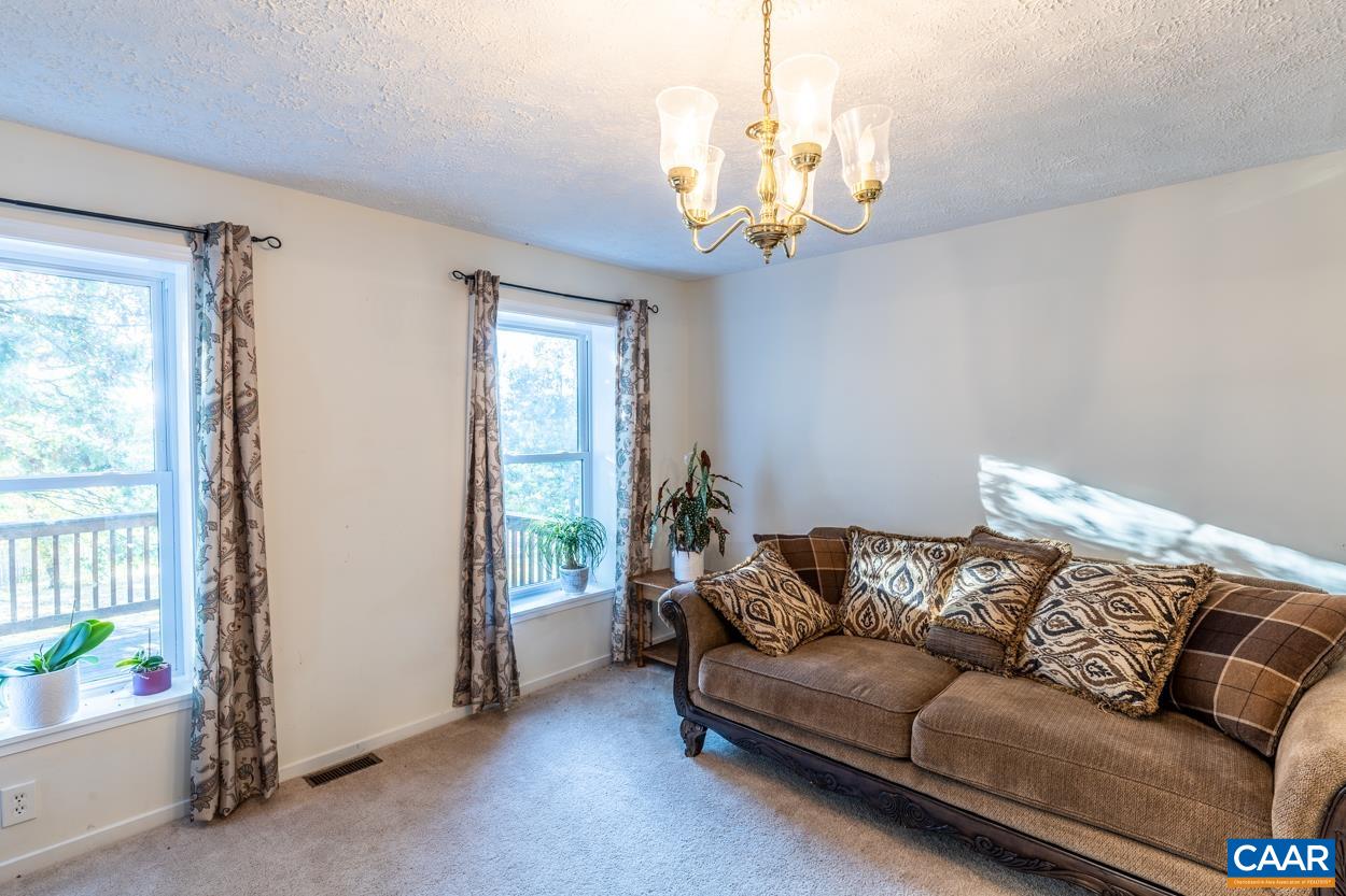 435 Courthouse Mountain Road Madison, VA 22727 - Photo 20 of 69 a living room with furniture and a chandelier