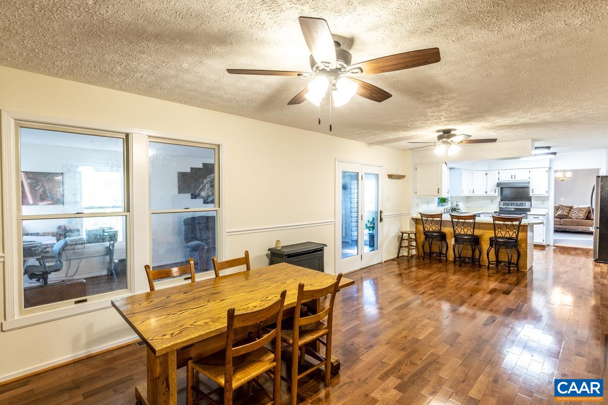 435 Courthouse Mountain Road Madison, VA 22727 - Photo 30 of 69 a dining room with stainless steel appliances kitchen island granite countertop a table chairs and a view of living room