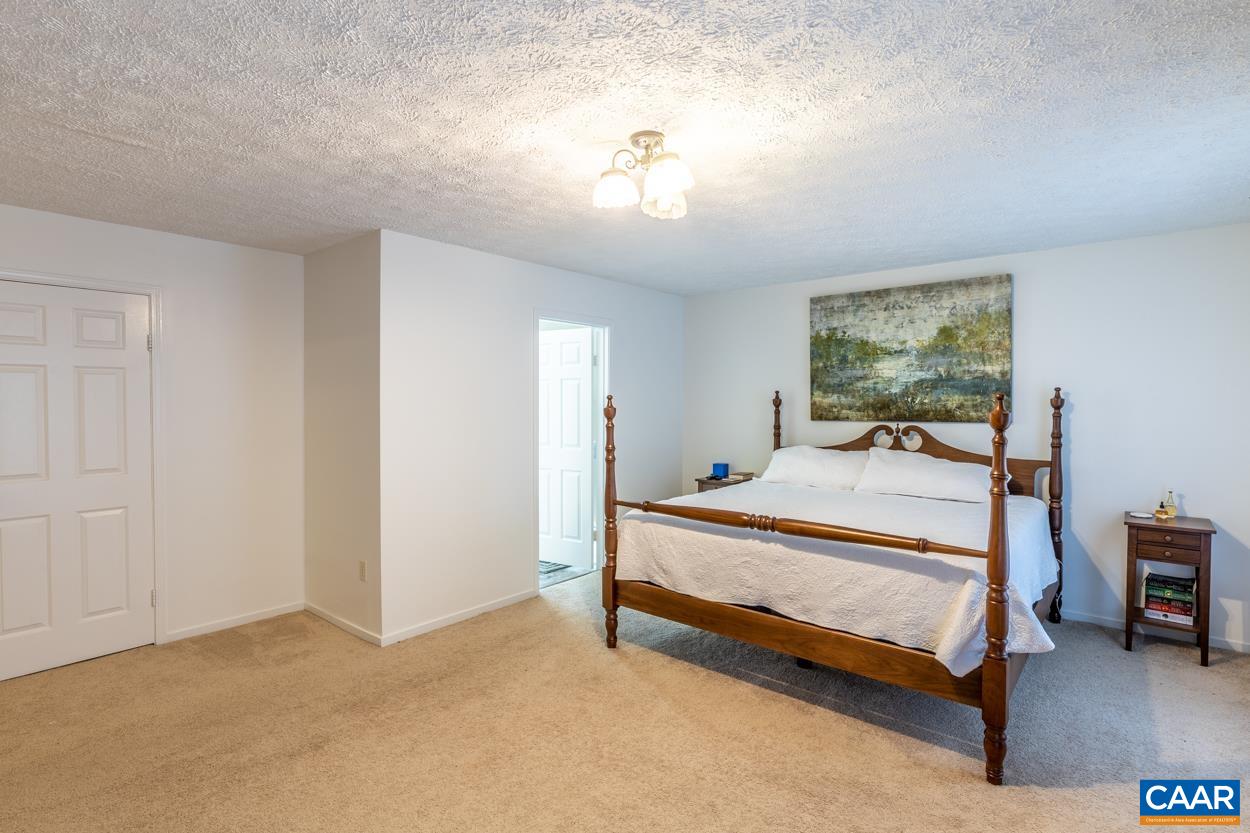 435 Courthouse Mountain Road Madison, VA 22727 - Photo 46 of 69 a bedroom with a bed and a chandelier