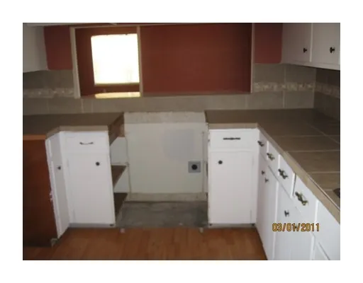 a kitchen with cabinets and wooden floor