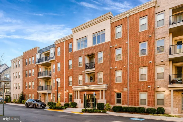 a front view of a building with lot of windows and trees