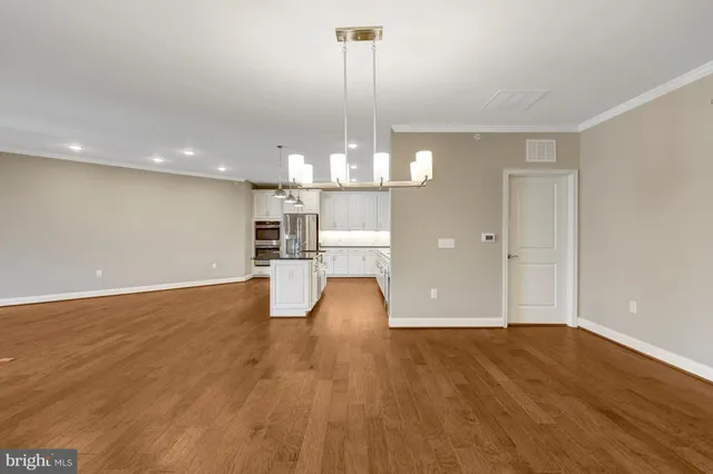 a view of a room with wooden floor fireplace and window