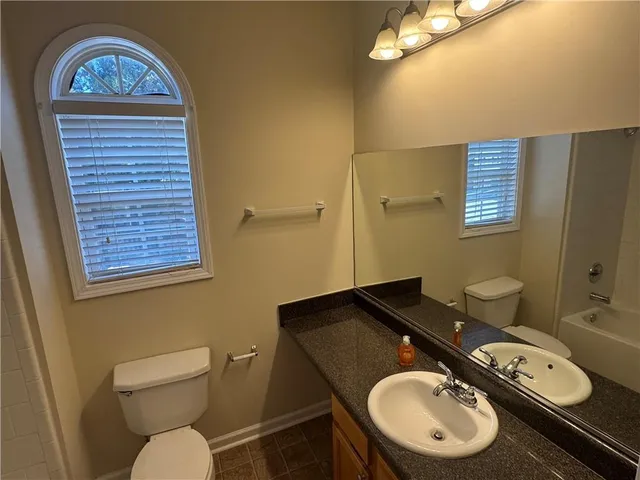 a bathroom with a toilet a sink and mirror