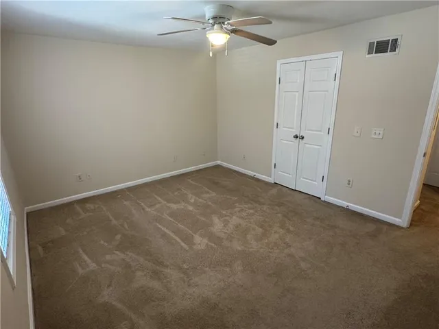 an empty room with a ceiling fan and a window