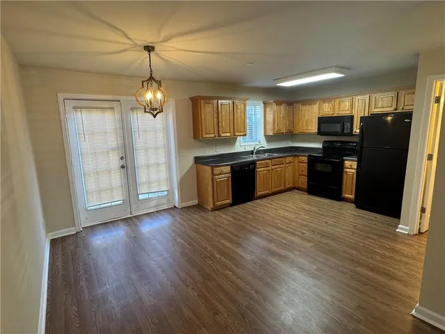a large kitchen with a wooden floor and stainless steel appliances