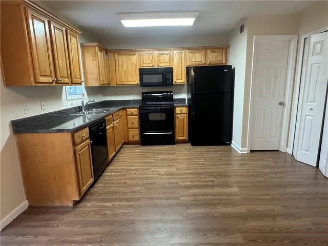 a kitchen with granite countertop a refrigerator and a stove top oven